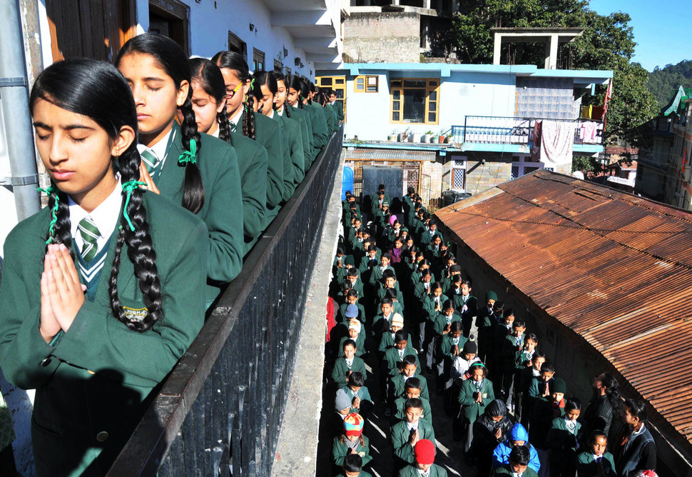 Indian schoolchildren pray during morning assembly at their school in Shimla on December 17, 2014, as they pay tribute to slain Pakistani schoolchildren and staff after an attack on an army school in the restive city of Peshawar. Pakistan began three days of mourning on December 17, for the 132 schoolchildren and nine staff killed by the Taliban in the country's deadliest ever terror attack as the world united in a chorus of revulsion. The 141 people were killed when insurgents stormed an army-run school in the northwestern city of Peshawar and systematically went from room to room shooting children during an eight-hour killing spree. AFP PHOTO/STR (Photo credit should read STRDEL/AFP/Getty Images)