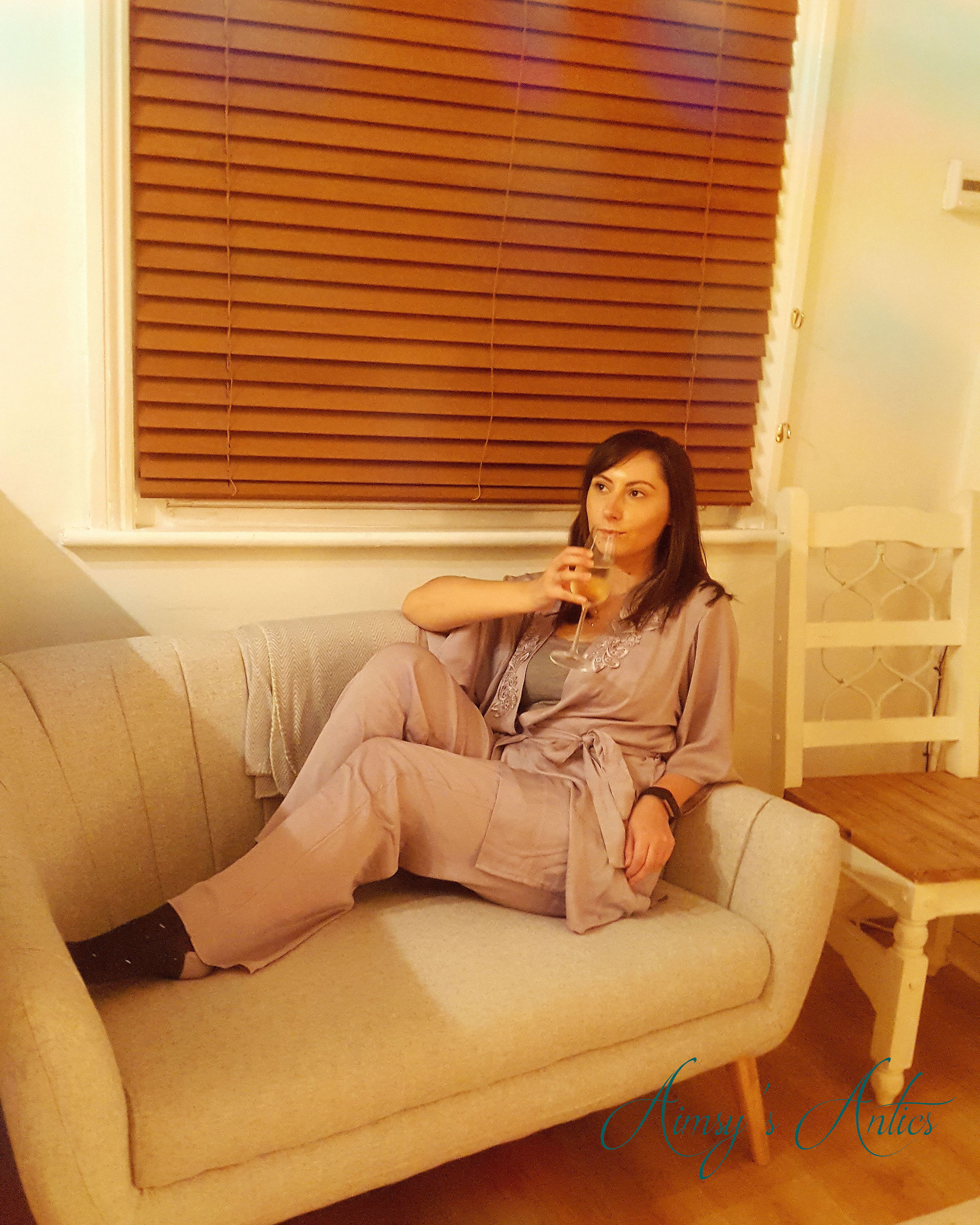 Woman sat on a sofa drinking Prosecco in Grange-over-Sands