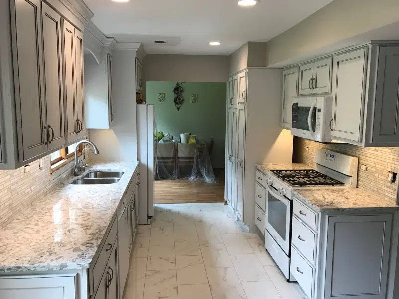 The bailey family beams in their remodeled kitchen featuring gray walls. Galley Kitchen Remodel Am Kitchen Bath