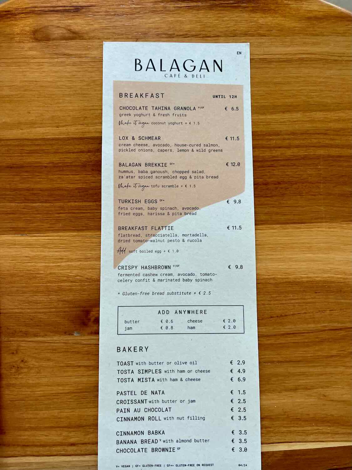 Menu from Balagan Caf&eacute; & Deli showing breakfast options such as Chocolate Tahina Granola, Lox & Schmear, Balagan Brekkie, Turkish Eggs, Breakfast Flattie, and Crispy Hashbrown. The menu also lists bakery items and additional options like toast, croissant, cinnamon roll, and chocolate brownie.