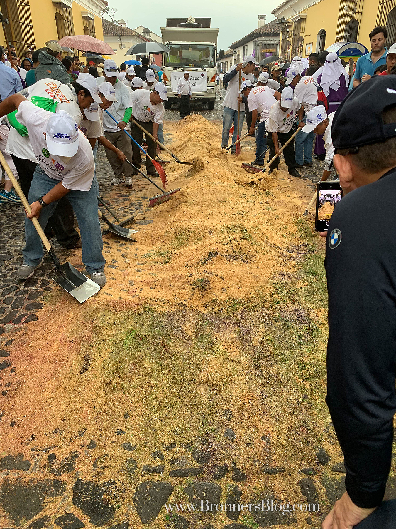 Sanitation crews cleaning up a flower carpet from the streets of Antigua.
