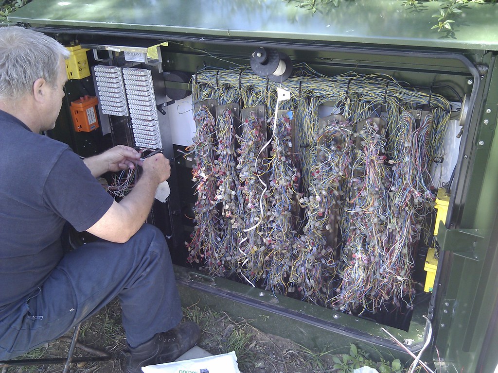 Something unsafe at a site where we're working; BT Openreach engineer patching old cabinet to fibre cabine