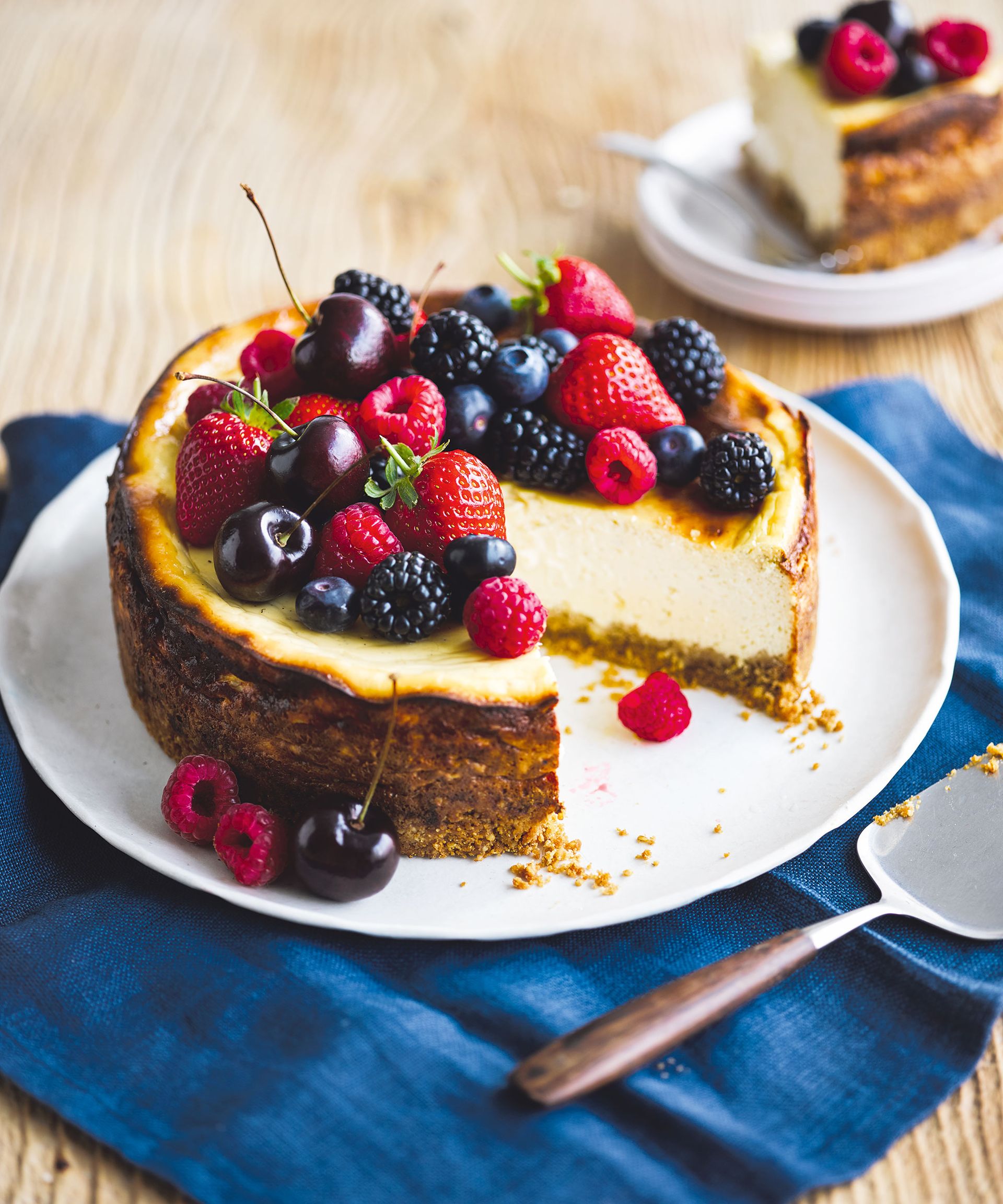 New York-style cheesecake made on a white plate wooden table with blue napkin