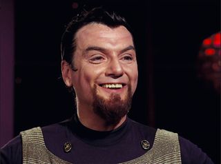 un extraterrestre humanoide barbudo muestra una sonrisa