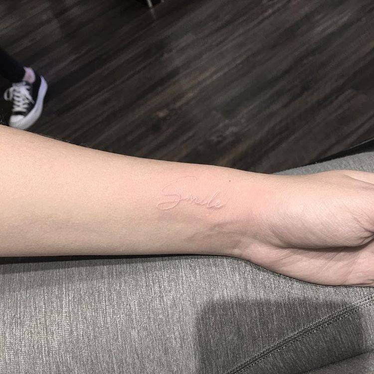 White Ink “Smile” Tattoo On The Left Inner Wrist. 750_x_750_jpg