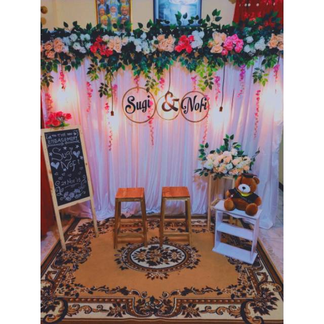 Warna putih jadi sentral dengan layar sutera pada spot foto, sedangkan meja dan kursi juga didominasi putih di lengkapi hiasan bunga layering pada bagian pentas . PAKET USAHA DEKORASI LENGKAP LAMARAN PERNIKAHAN TUNANGAN