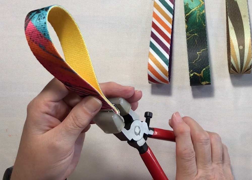 Photo showing the process of closing the hardware with the pliers for today's How to Sublimate Wristlet Keychains post.