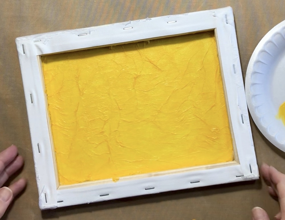 Photo of the inside of the canvas after applying the tissue paper and painting it with Liquitex Basics Cadmium Yellow Deep Hue.