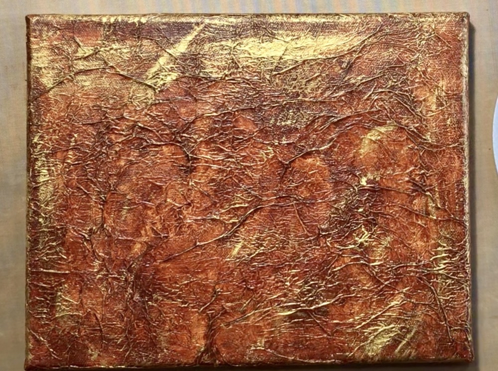 Photo of the front of the canvas after applying a light coat of Liquitex Basics Gold with a dry brush technique.