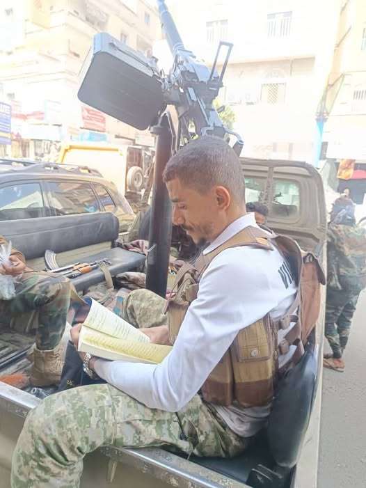 بندقية بيده وكتاب بالأخرى.. صورة جندي يذاكر دروسه أثناء الواجب تجتاح منصات التواصل