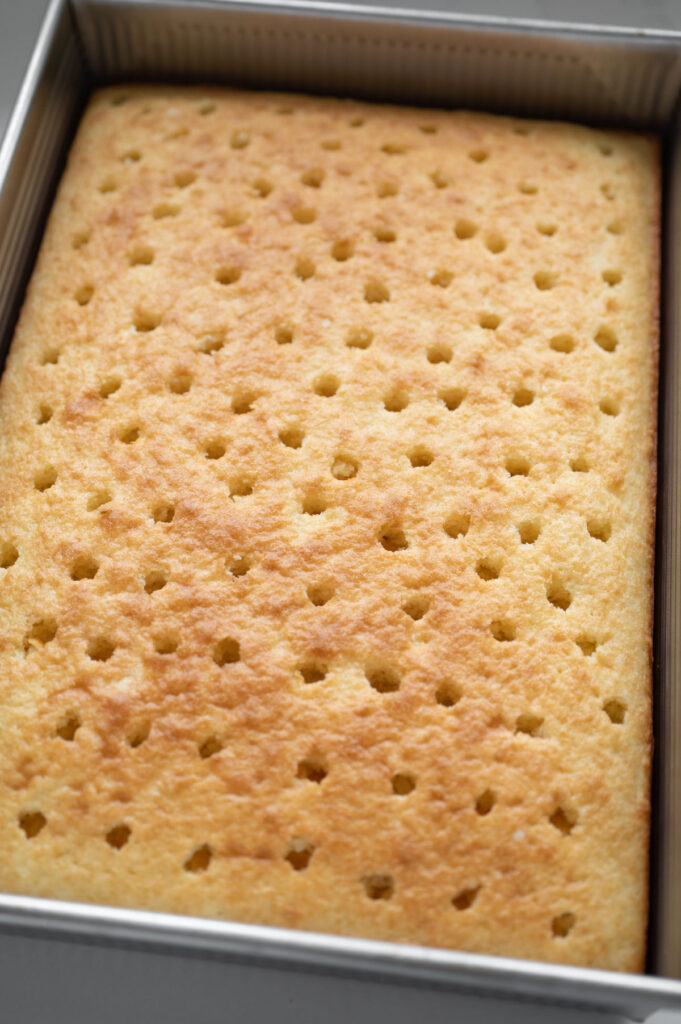 A 9x13 inch cake with holes poked into it.