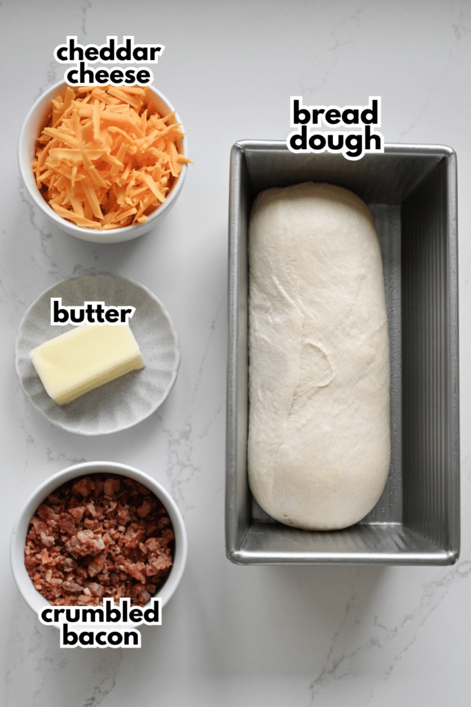 The ingredients needed to make a pan of bacon cheddar rolls labeled with the ingredient name.