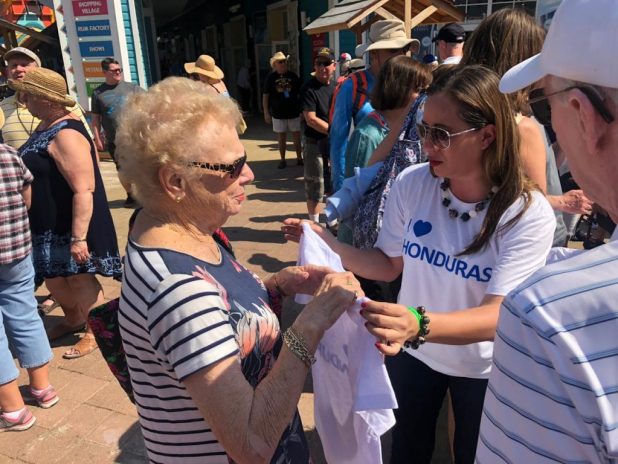 Nicolle Marder, ministra de turismo entregando camisetas.