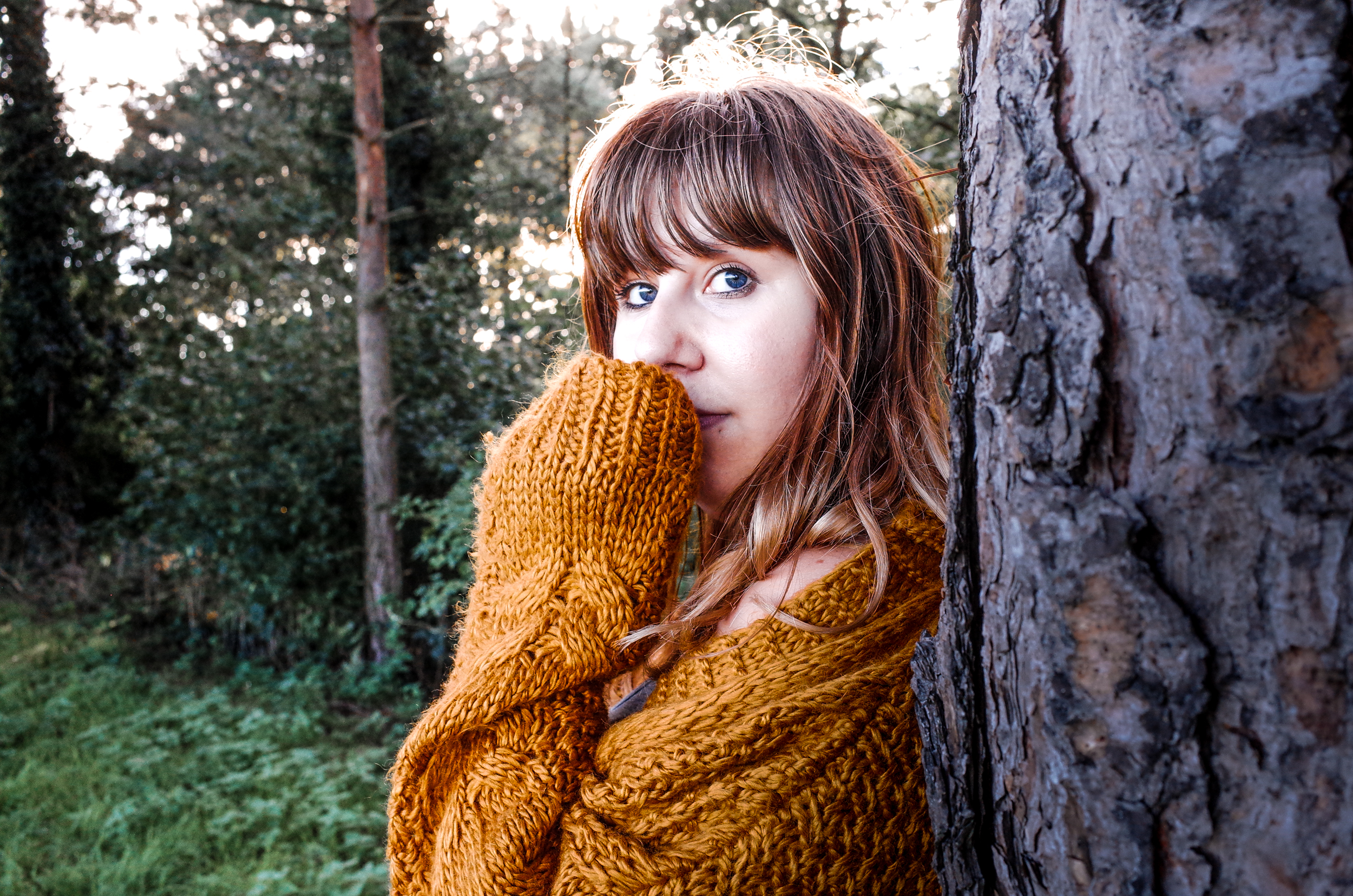 Louise stares at the camera in an oversized yellow cardigan from Joe Browns