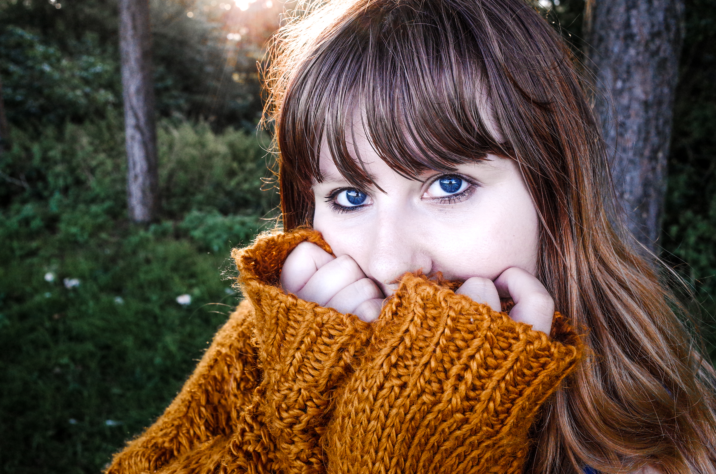 Louise stares into the camera with her hands covering her face, looking cosy in her Joe Browns'  mustard yellow slouchy cardigan