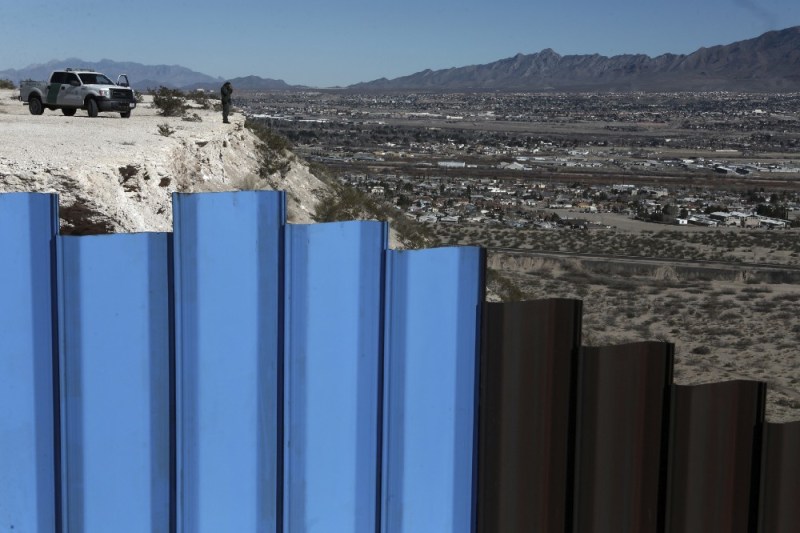 An agent of the border patrol, observes near the Mexico-US border fence, on the Mexican side, separating the towns of Anapra, Mexico and Sunland Park, New Mexico, on January 25. CREDIT: AP Photo/Christian Torres.