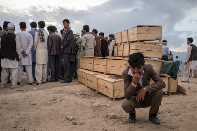 ethnic Hazara man cries next to empty caskets on Sunday during burial ceremonies at a cemetery in the Omid-e-Sabz Township near Kabul, Afghanistan. Credit Adam Ferguson for The New York Times