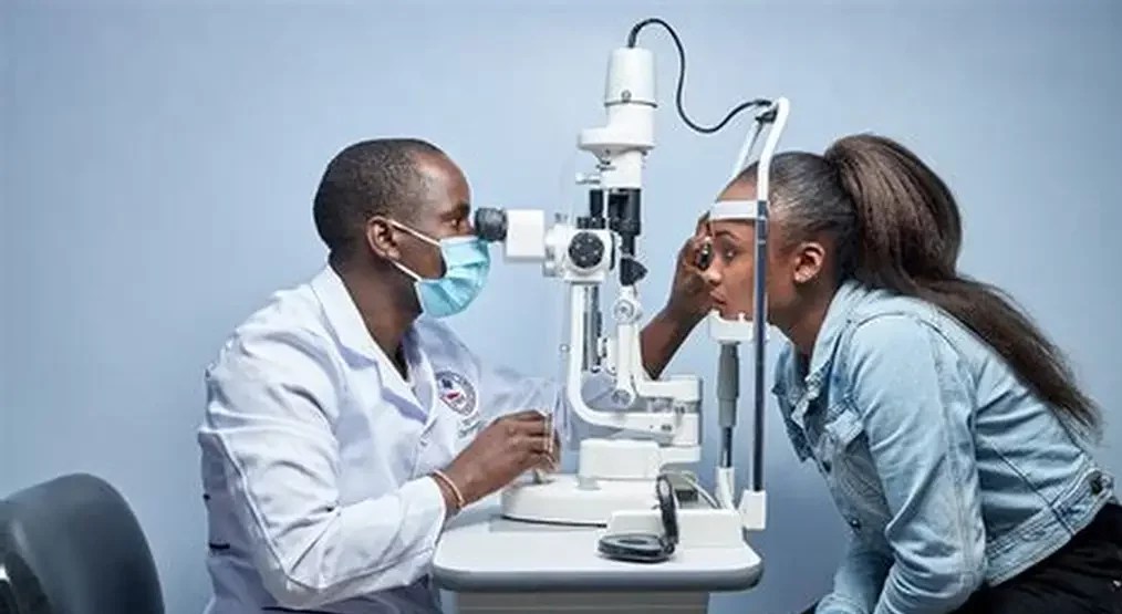A doctor/optometrist examining a patient’s eye.