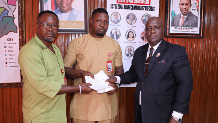 Handing over a draft of recovered N80,000,000 to Ifeanyi Innocent Madueke