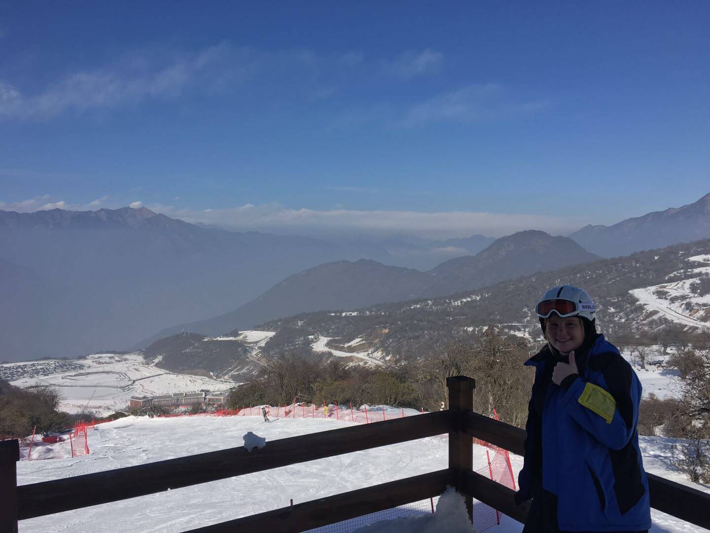 woman smiling in front of ski resort