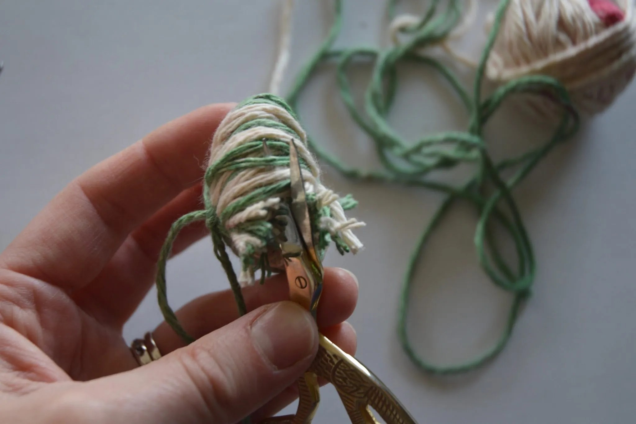 Cutting the yarn loops of the pom pom.