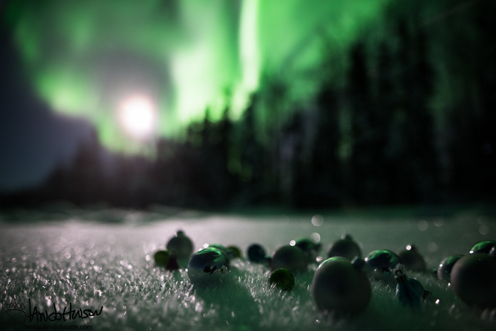 A big moon shadows the ornaments, and is a brilliant aurora reflection shines from overhead.