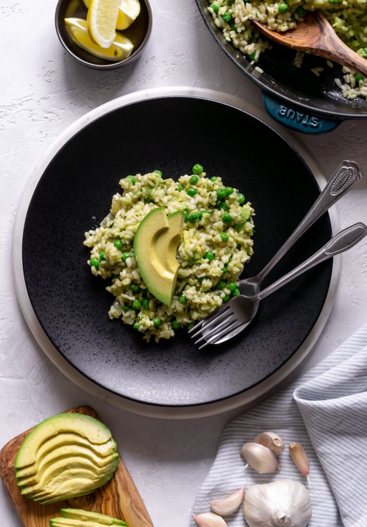 a black place with risotto and sliced avocado