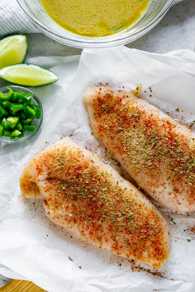 seasoned chicken on white parchment paper