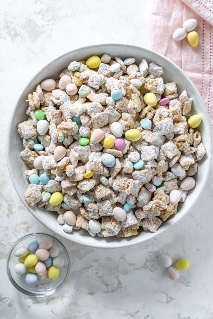 puppy chow in a large white bowl with a pink napkin