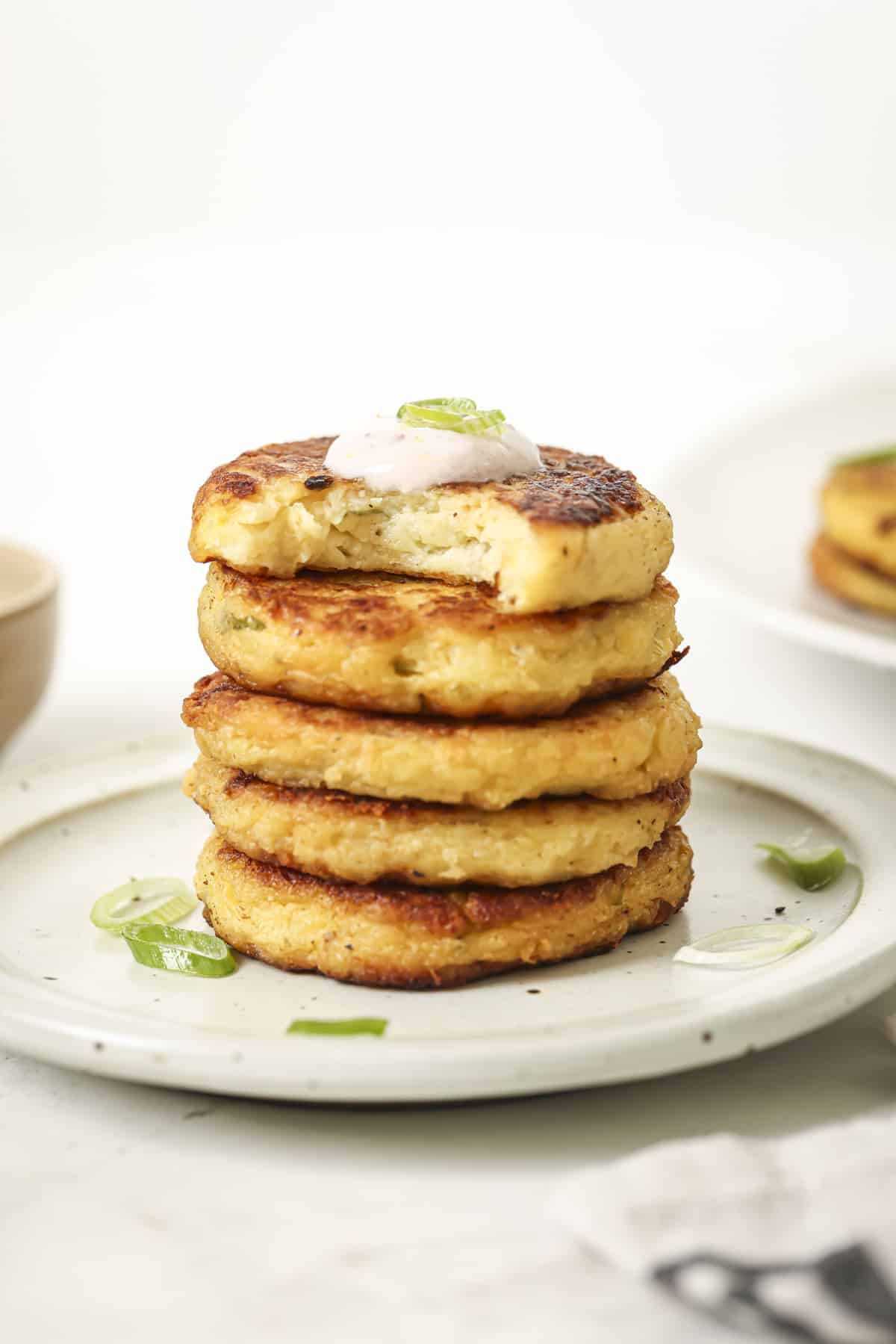 Stacked potato cakes with a dollop of creamy sauce on top.