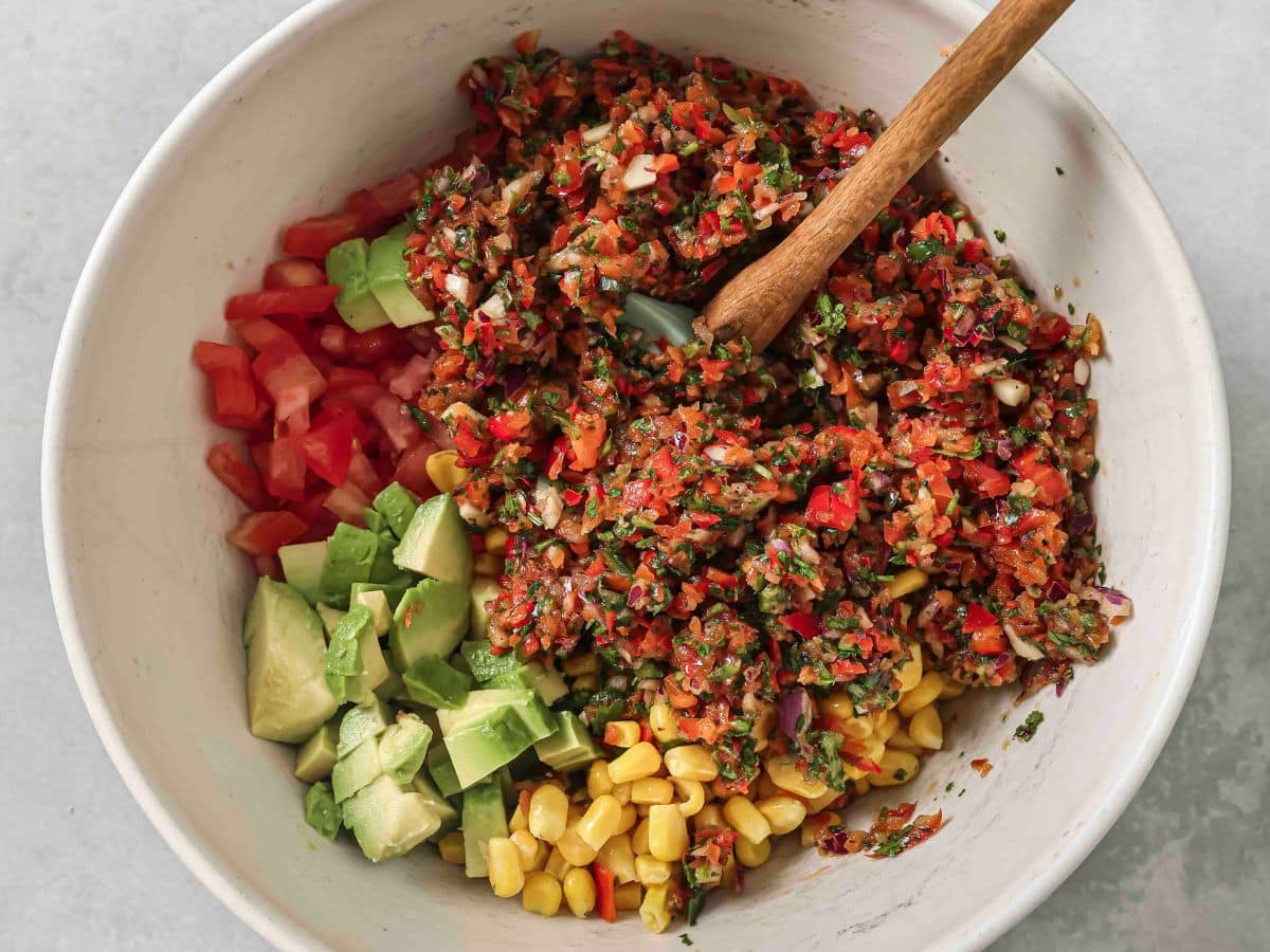 Gently combining the ingredients with a wooden spatula. 