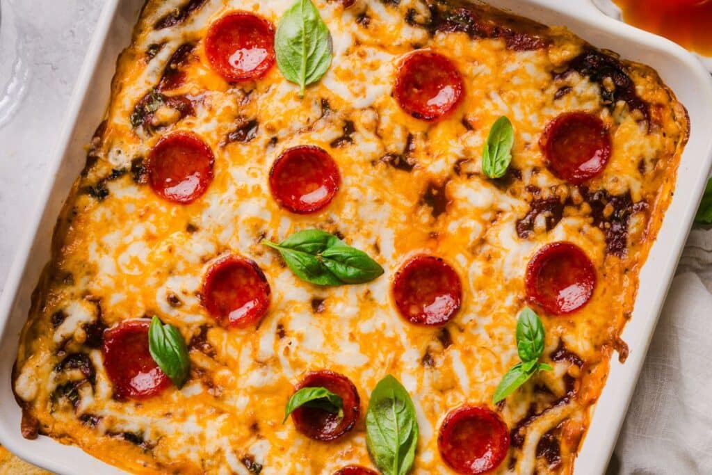 Baked, finished pizza dip with fresh basil on top. 