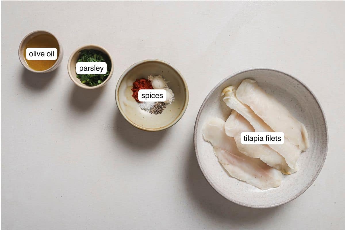 Flat lay of air fryer tilapia ingredients labeled on a white surface. 
