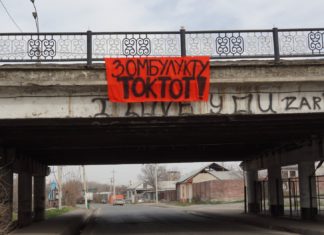 Бир кадр менен: Ош шаарындагы эски көпүрөгө аялдарга карата зомбулукка каршы плакат илинди