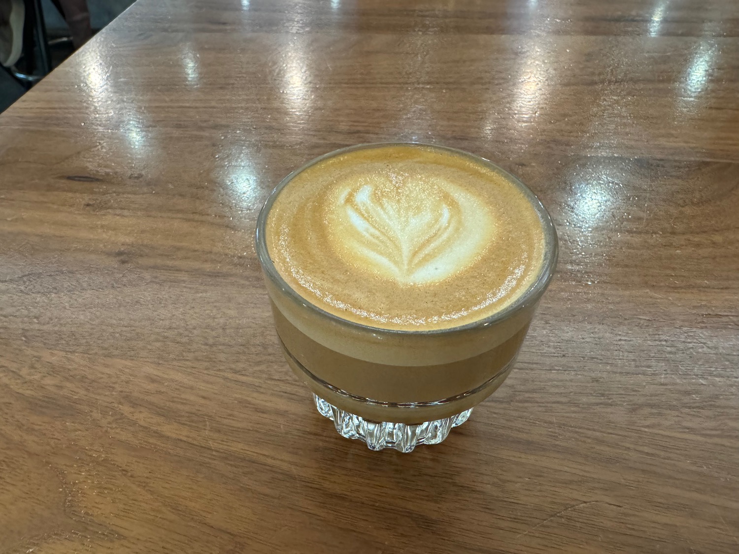 a glass cup of coffee on a table