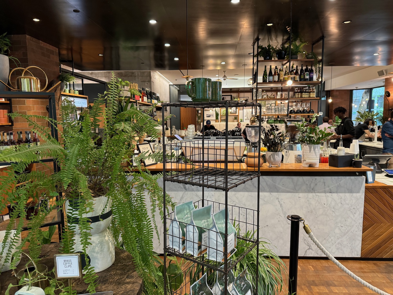a room with a bar and shelves with plants and a man and woman