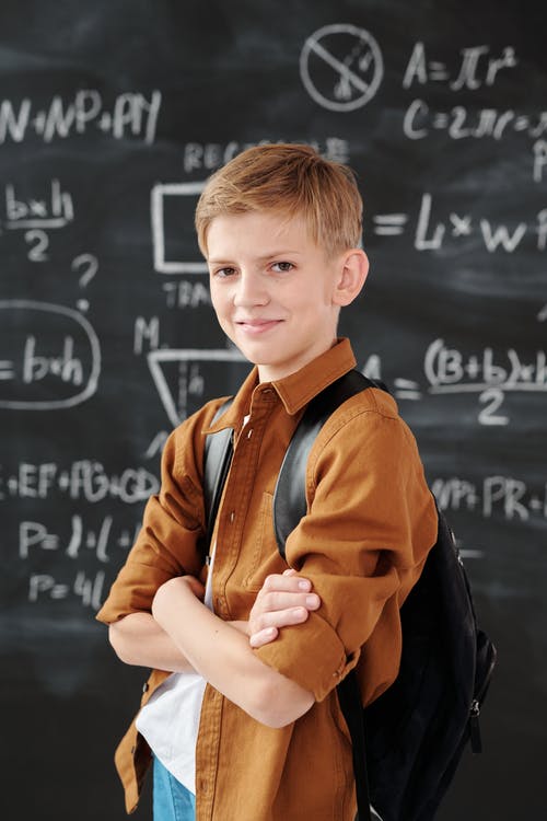 Student standing in front of a blackboard