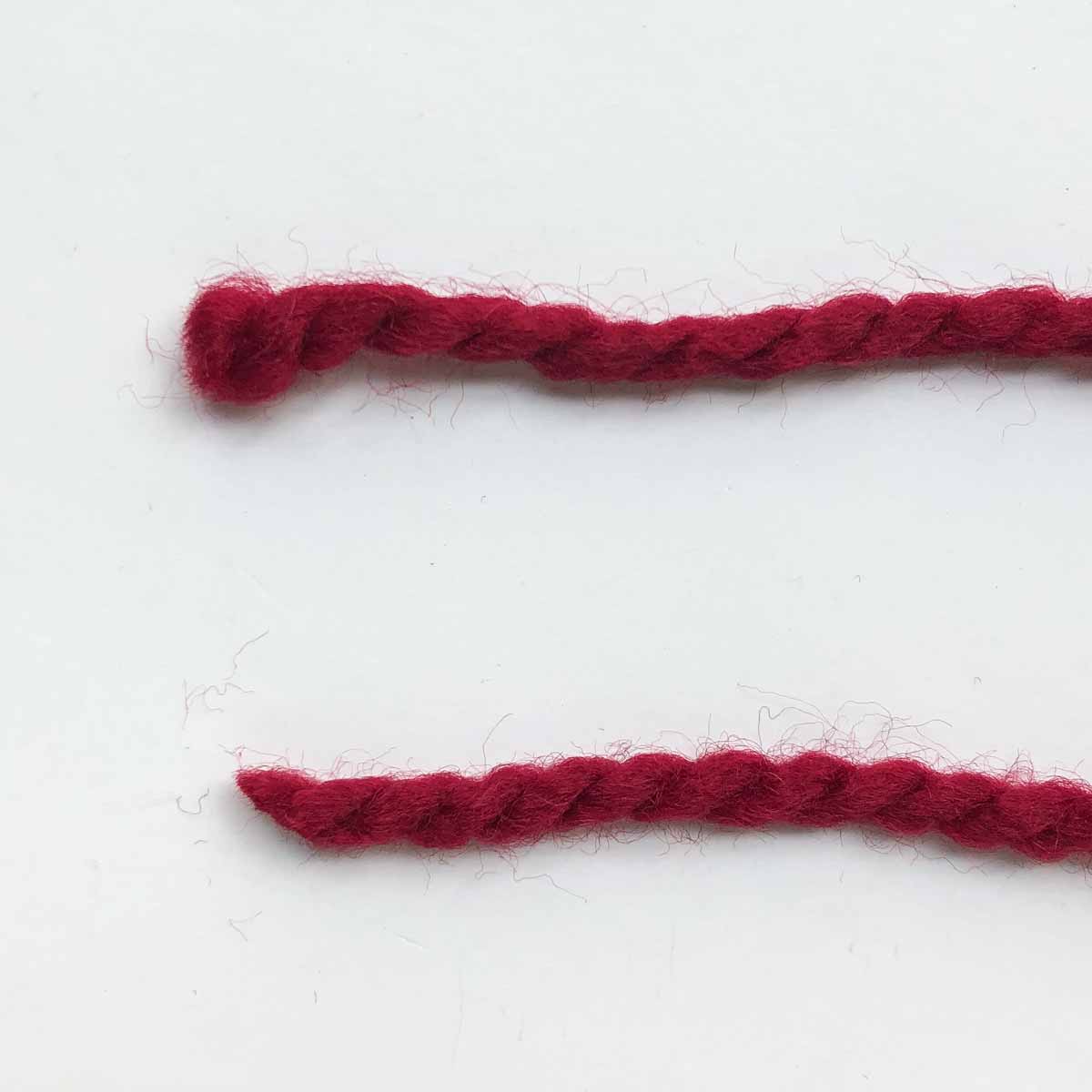 Shows tip of yarn. Top yarn cut with dull scissors, bottom yarn cut with shar scissors