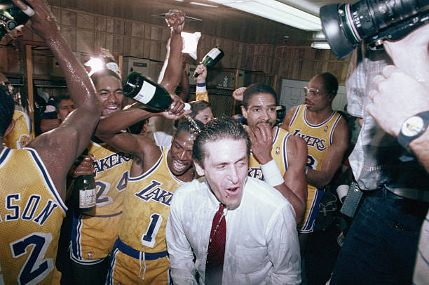 Los Angeles Lakers coach gets a champagne bath from his team as he enters the locker room after the Lakers won the NBA Championship on 6/14.