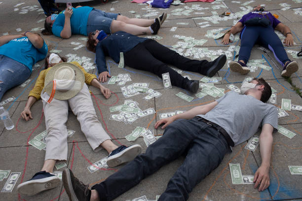 Friends and family members of people who have died during the opioid epidemic protest against a bankruptcy deal with Purdue Pharmaceuticals that allows the Sackler family to avoid criminal prosecution and to keep billions of dollars in private wealth, on August 9, 2021 outside the Federal courthouse in White Plains, New York. For decades the Sackler family, which owned Purdue, knowingly marketed highly addictive painkillers, including Oxycontin.
Photo Credit: Andrew Lichtenstein/Corbis via Getty Images