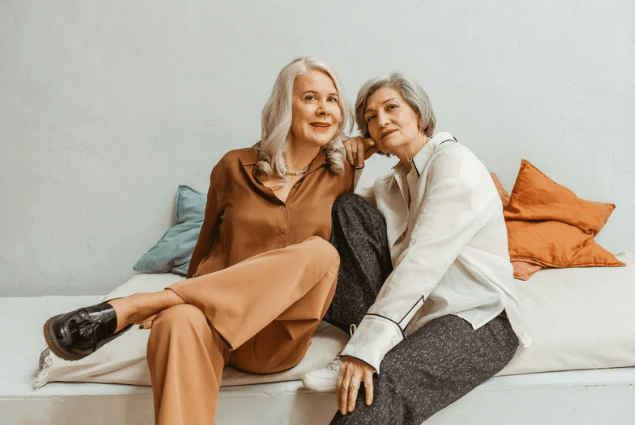 Two older women sit on a couch while going over menopause resources provided by OGA Idaho.