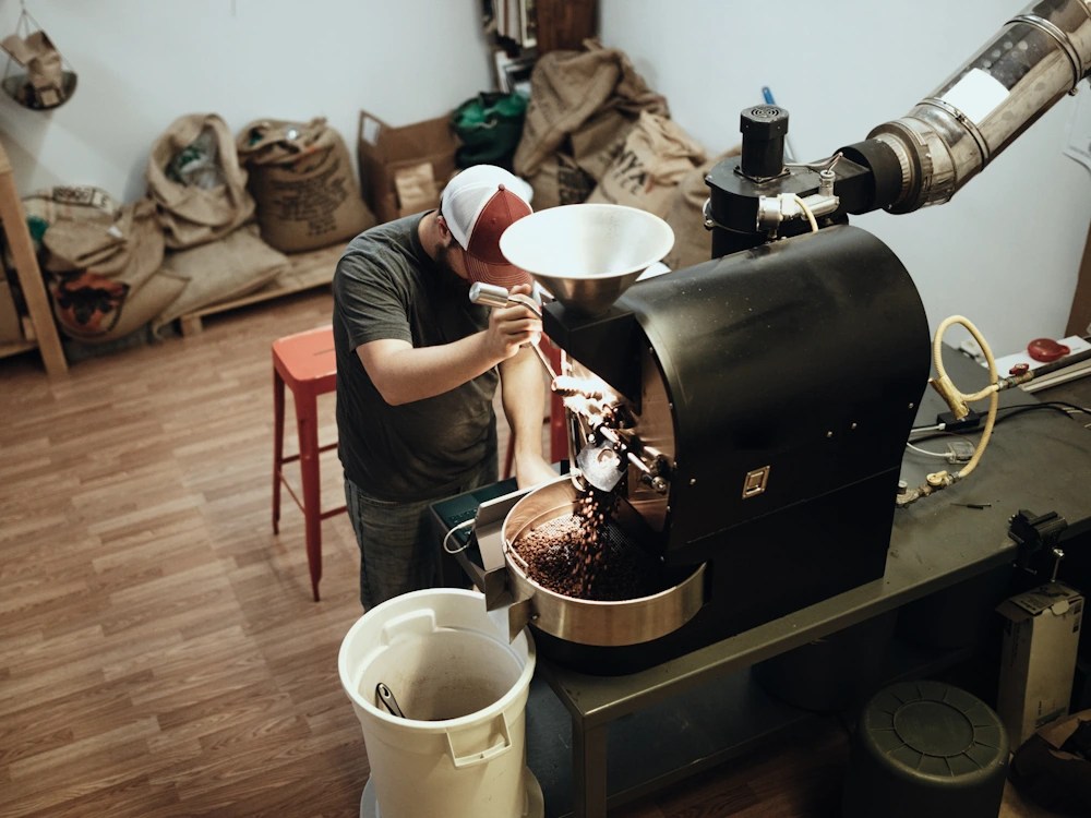 - Healthy Brew Hub Roaster using small machine and emptying into a cooling tray.