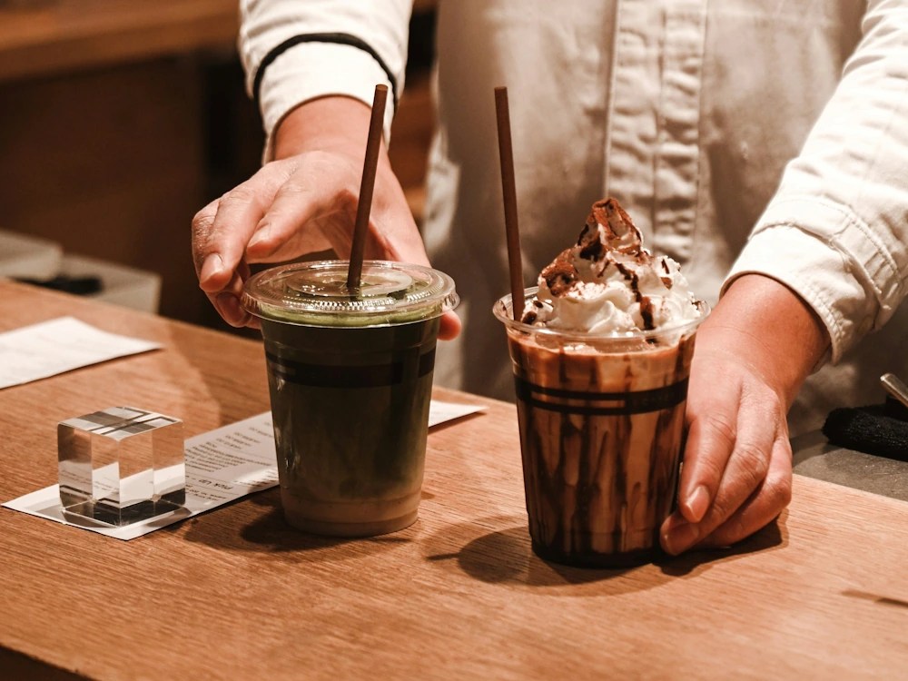 - Healthy Brew Hub A barista serves iced matcha lattes and coffee drinks.