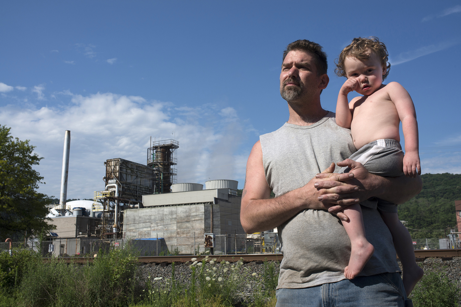 Rob Sickles with his son Spencer, 3, on the street between his home and the Dyno Nobel plant in Donora.