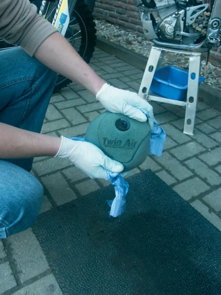 Leicht drücken – nie wringen: Den Filter in den Behälter mit Öl tauchen und danach ausdrücken und abtupfen mit „Zewa“.