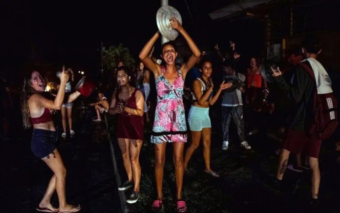 Mujeres cubanas golpean calderos en una protesta nocturna durante un apagón en La Habana