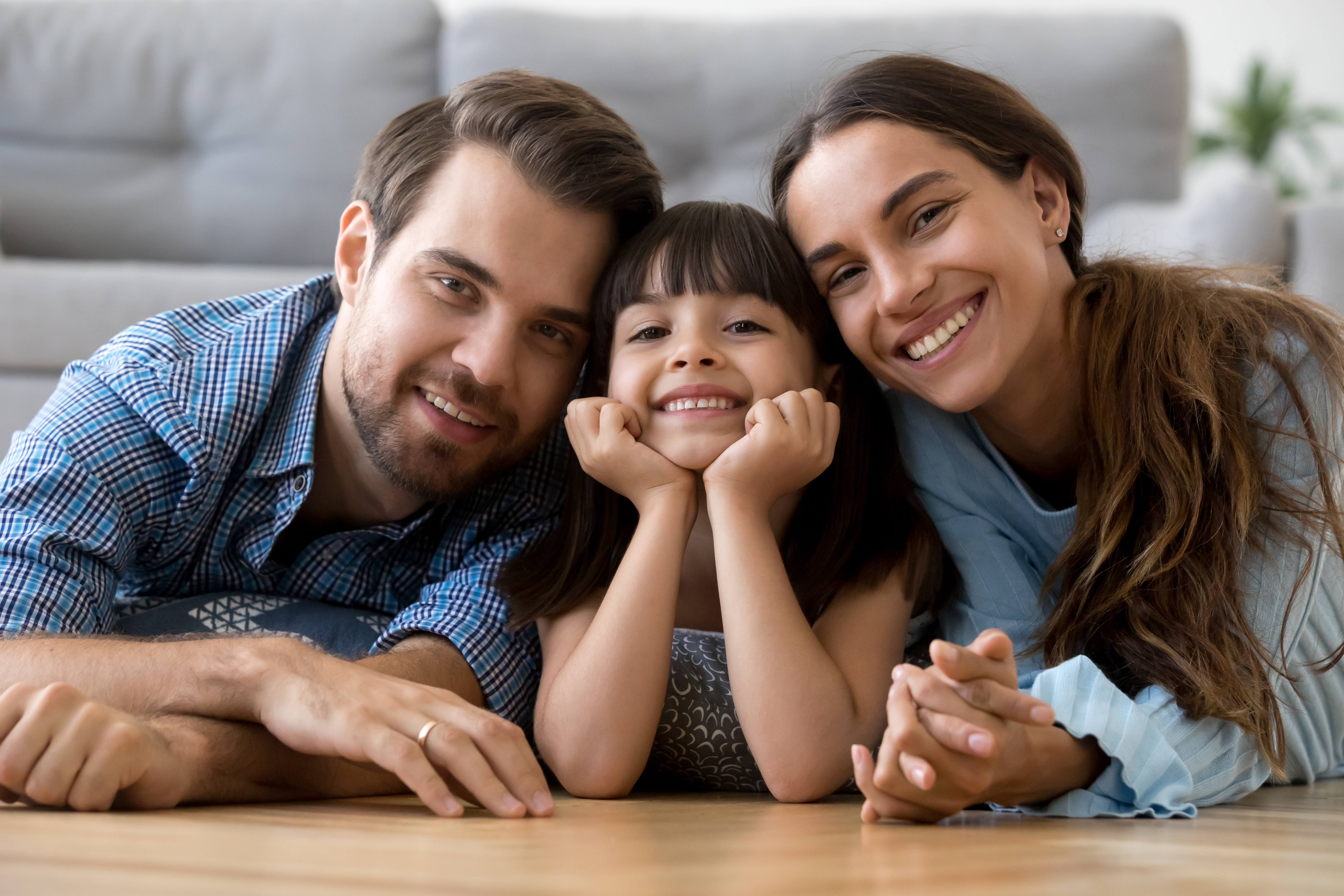 Diverse family, mom, dad, and child smiling at camera 
