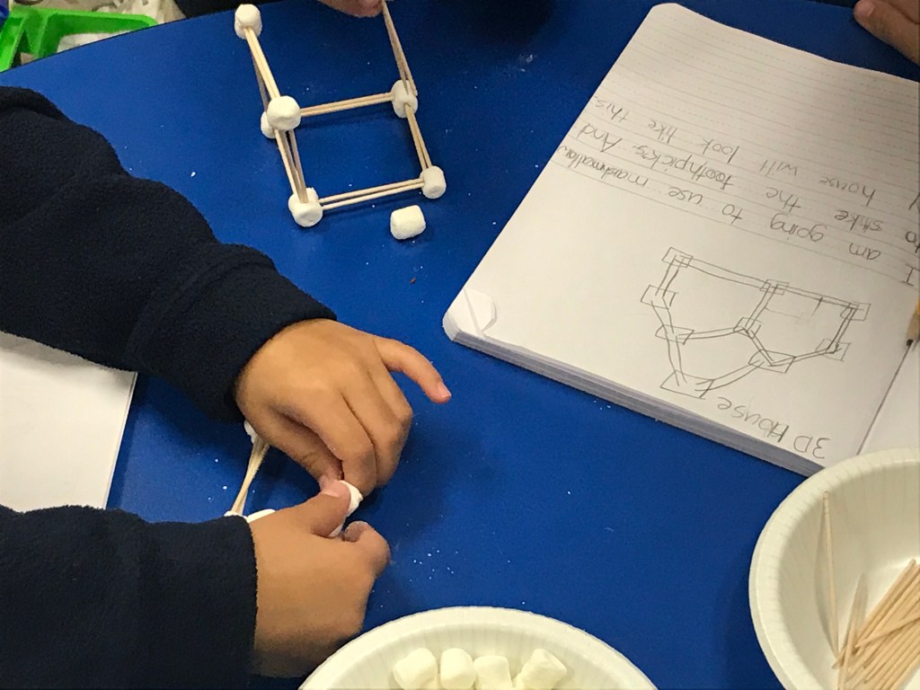 Picture of kids working on a STEM project building a 3D house.
