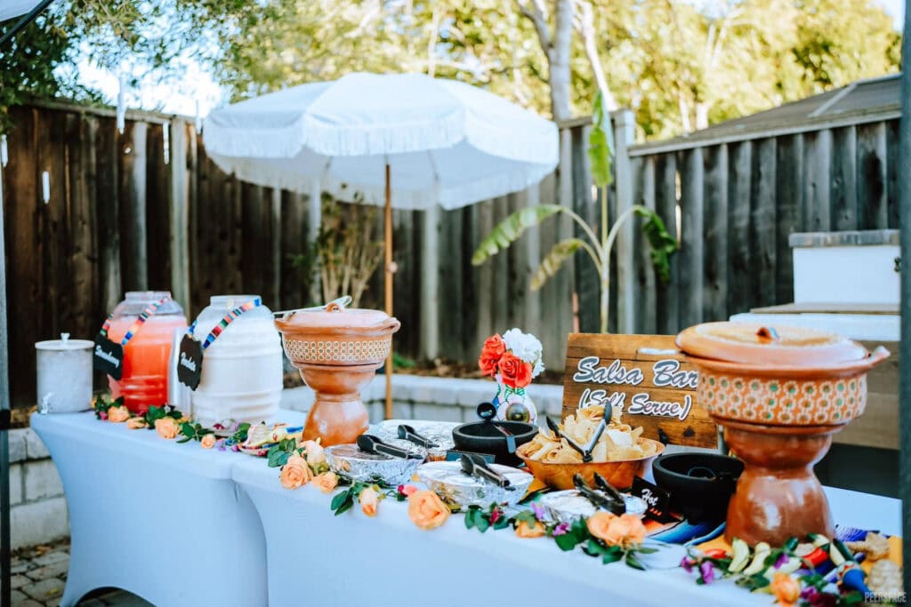 Drink pitchers and a salsa bar at an outdoor event