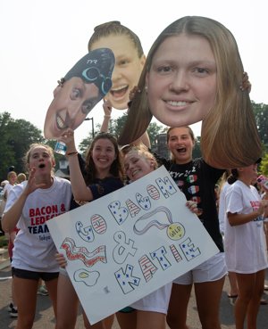 Students at Stone Ridge School of the Sacred Heart in Bethesda, Md., hold large cardboard cutouts of swimmers Katie Ledecky and Phoebe Bacon and cheer on their Olympic-bound alumnae during a pep rally July 19, 2021. The Tokyo Olympics begin July 23.